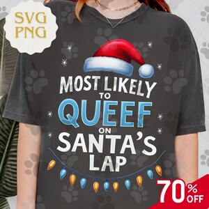 May include: Dark gray t-shirt with the text "MOST LIKELY TO QUEEF ON SANTA'S LAP" in white and blue, topped with a Santa hat. A string of colorful lights is at the bottom. The shirt has a 70% off sale tag.