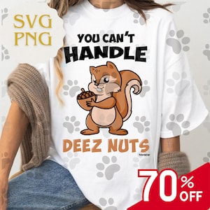 Op de afbeelding: Wit t-shirt met een cartoon eekhoorn die een eikel vasthoudt. Het shirt heeft de tekst "YOU CAN'T HANDLE DEEZ NUTS" in zwart en bruin. Voetafdrukken zijn verspreid rond het ontwerp.