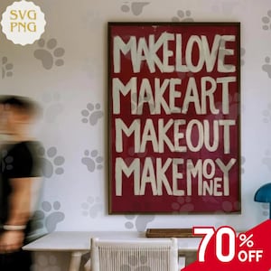 以下が含まれることがあります： 赤い背景に白いブロック文字で「MAKE LOVE MAKE ART MAKE OUT MAKE MONEY」と書かれた額入りのアートワーク。アートワークは、足跡のデカールが付いた白い壁に掛けられています。