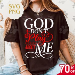 May include: A black t-shirt with the text "GOD DON'T PLAY ABOUT ME" in white and red. The shirt has a crew neck and short sleeves. The image also includes a "70% OFF" sale tag.