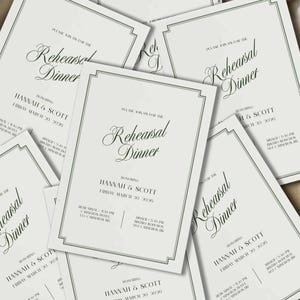 May include: Off-white rehearsal dinner invitations with elegant script and a decorative border. The invitations read "Rehearsal Dinner" and include the names "Hannah & Scott" and the date "Friday March 20 2026".