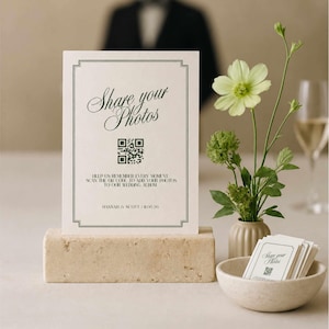 Könnte beinhalten: Ein rechteckiges weißes Schild mit schwarzem Rand, dem Text Share your Photos, einem QR-Code und dem Text Hannah & Scott | 11.05.26. Das Schild steht auf einem rechteckigen Steinblock neben einer kleinen Schale mit kleineren passenden Karten.