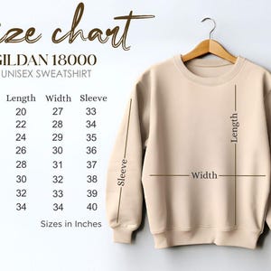 May include: A beige Gildan 18000 unisex sweatshirt hangs on a wooden hanger. A size chart shows measurements in inches for sizes S to 5XL, including length, width, and sleeve dimensions. The chart is labeled "Size chart".