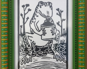Frog Playing the Jug Woodcut Print in Decorated Frame