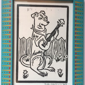 Dog Playing Ukulele Woodcut Print in Decorated Frame