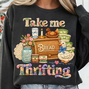 Pu&ograve; includere: Felpa grigio scuro con un design ricamato colorato. Il design include le parole "Take me Thrifting", una cassetta del pane, un'anatra, un barattolo e altri elementi decorativi. La felpa &egrave; uno stile casual e confortevole.