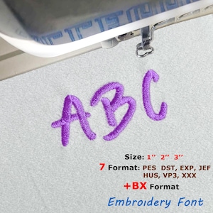 Op de afbeelding: Close-up van geborduurde letters "ABC" in paars garen op een witte stof. De afbeelding bevat maatopties van 2.5 cm, 5 cm en 7.6 cm, en verschillende borduurformaten. De tekst geeft ook aan dat dit een borduurlettertype is.