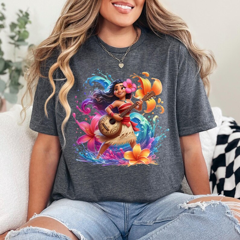 May include: Dark gray t-shirt featuring a vibrant illustration of a Polynesian woman playing a ukulele. The design includes colorful flowers, water splashes, and a tropical theme. The shirt is made of a soft material.