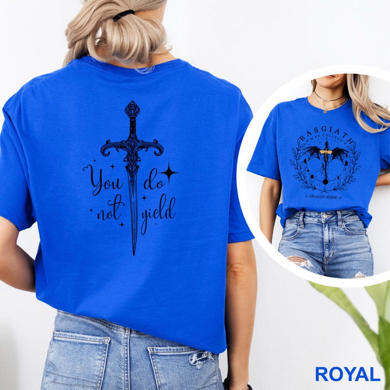 May include: Royal blue t-shirt with a black sword graphic and the text "You do not yield." A second image shows a similar shirt with a different graphic and text. The shirt is a short-sleeved crew neck.
