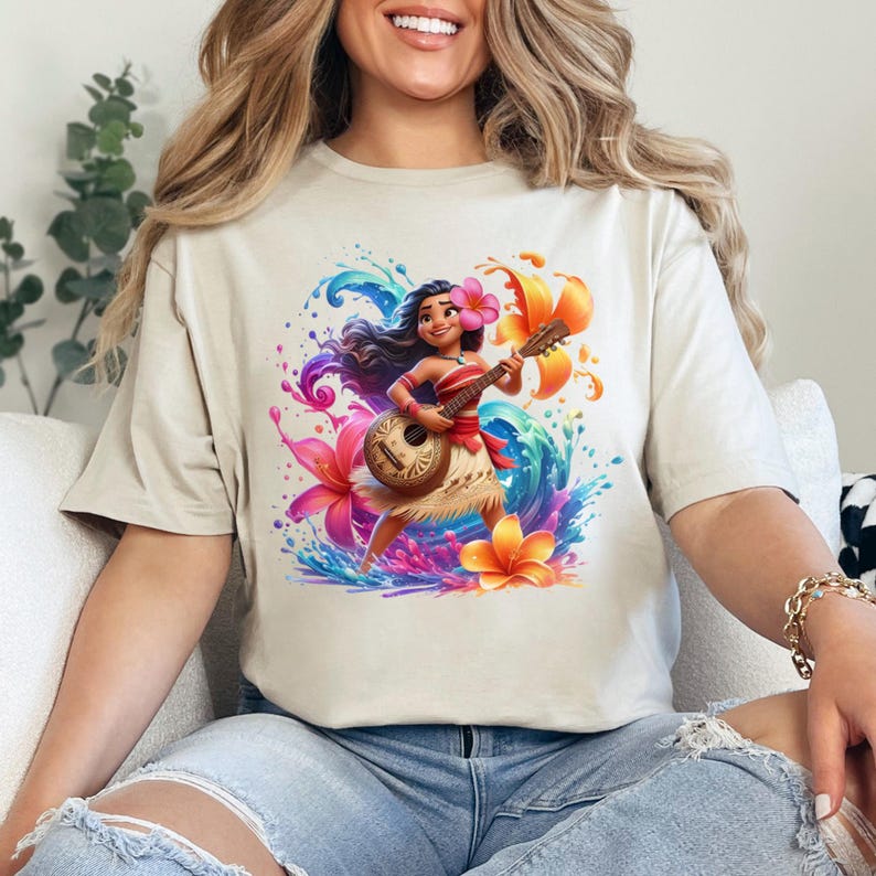 May include: Beige t-shirt featuring a vibrant illustration of a cartoon character playing a ukulele. The design includes colorful flowers, water splashes, and a tropical theme. The character is wearing a red top and a grass skirt.