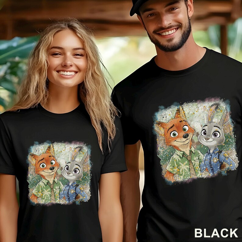 K&ouml;nnte beinhalten: Schwarze T-Shirts mit einer farbenfrohen Grafik von Nick Wilde und Judy Hopps aus Zoomania. Die Zeichentrickfiguren sind in einem Aquarellstil dargestellt. Das Wort "BLACK" ist unten im Bild in Wei&szlig; gedruckt.