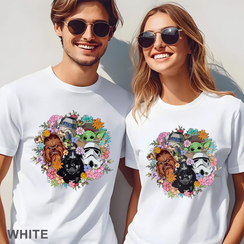 Puede incluir: Camisetas blancas con un dise&ntilde;o floral con personajes de Star Wars. El dise&ntilde;o incluye a Darth Vader, un Stormtrooper, Chewbacca, R2-D2 y Baby Yoda, rodeados de flores. La palabra "WHITE" est&aacute; impresa en la parte inferior.