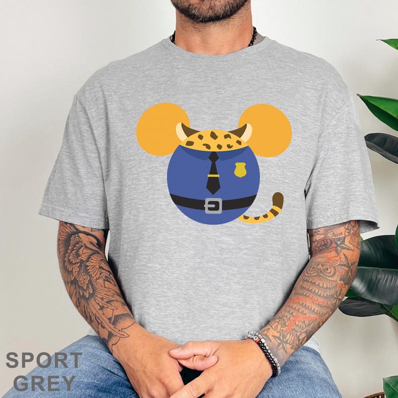 Puede incluir: Camiseta gris deportiva con un dise&ntilde;o de dibujos animados de un rat&oacute;n vestido de polic&iacute;a. El rat&oacute;n tiene orejas amarillas, un uniforme azul con corbata, cintur&oacute;n y placa negros, y una cola a rayas. El texto "SPORT GREY" est&aacute; impreso en la parte inferior.