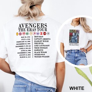 May include: White t-shirt with the text "AVENGERS THE ERAS TOUR" and a list of dates and characters such as Iron Man and Captain America. A smaller image of Captain America is on the right side of the shirt.