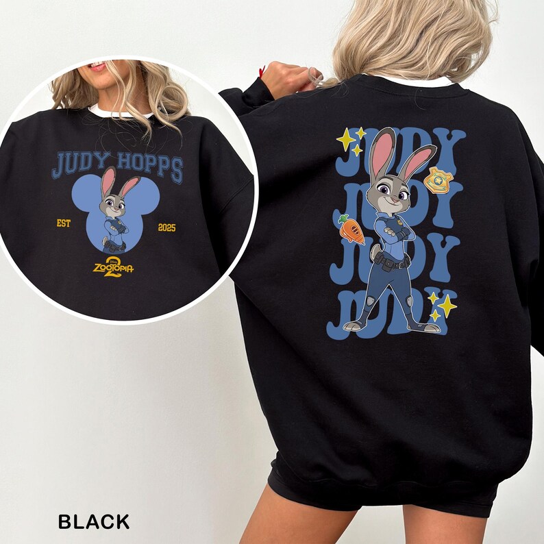 May include: Black sweatshirt featuring Judy Hopps from Zootopia 2. The front design includes the text "JUDY HOPPS" above a cartoon image of Judy Hopps inside a blue Mickey Mouse-shaped design. The back features Judy Hopps with the text "JUDY" repeated.