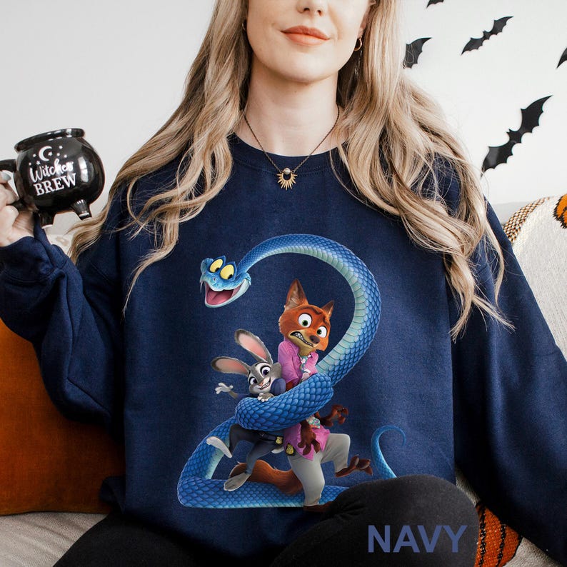 Op de afbeelding: Marineblauwe sweatshirt met een cartoonafbeelding van een blauwe slang die zich om een vos en een konijn wikkelt. De vos draagt een roze shirt, het konijn een pak. Het woord "NAVY" staat onderaan gedrukt. Halloween thema.