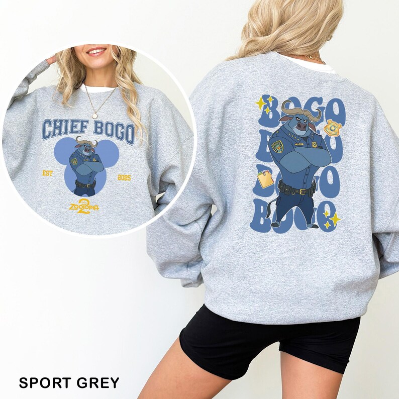 May include: A light gray sweatshirt featuring Chief Bogo from Zootopia. The front design includes the text "CHIEF BOGO" above an image of the character. The back of the sweatshirt has a larger graphic of Chief Bogo with the text "BOGO" repeated vertically.