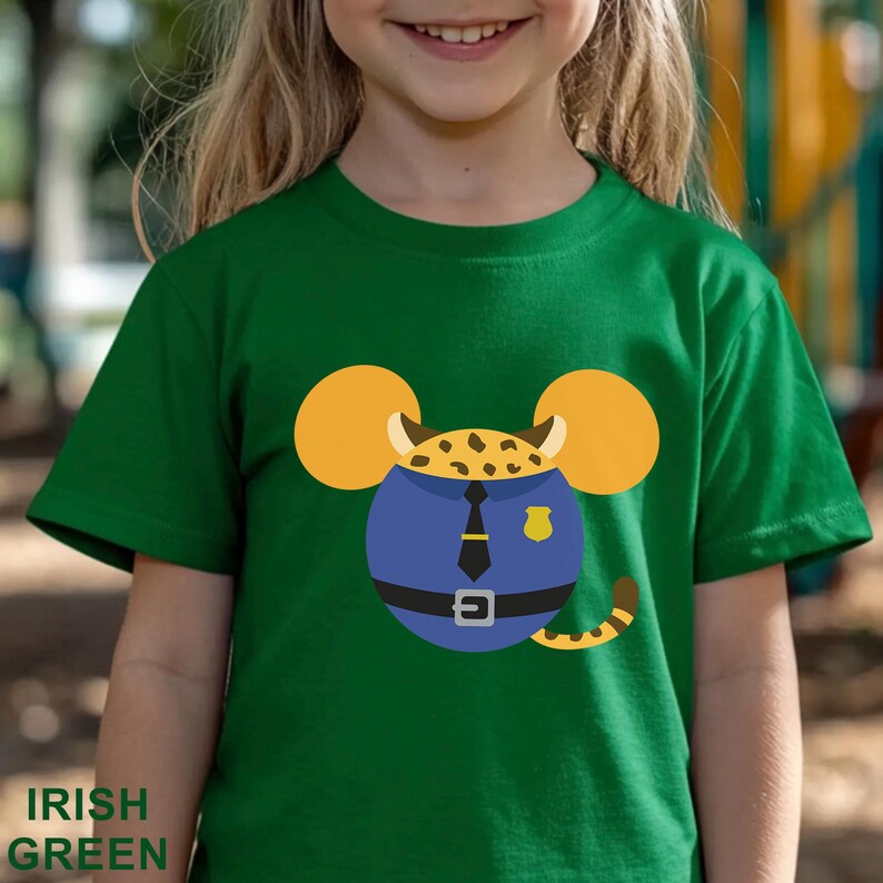 Puede incluir: Camiseta verde irland&eacute;s con un dibujo de un rat&oacute;n de dibujos animados vestido de polic&iacute;a. El rat&oacute;n tiene grandes orejas amarillas y un uniforme azul con corbata negra. El texto "IRISH GREEN" est&aacute; impreso en la parte inferior.