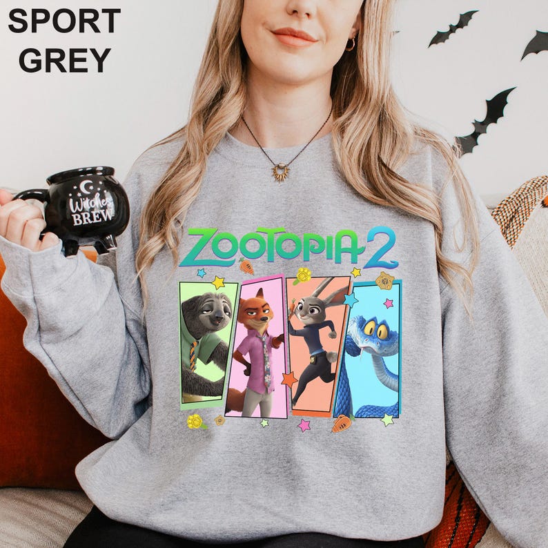 Może przedstawiać: Szara bluza sportowa z napisem "ZOOTOPIA 2" i postaciami z kresk&oacute;wek. Bluza ma okrągły dekolt i długie rękawy. Obrazek zawiera leniwca, lisa, kr&oacute;lika i węża. Bluza wykonana jest z miękkiego materiału.