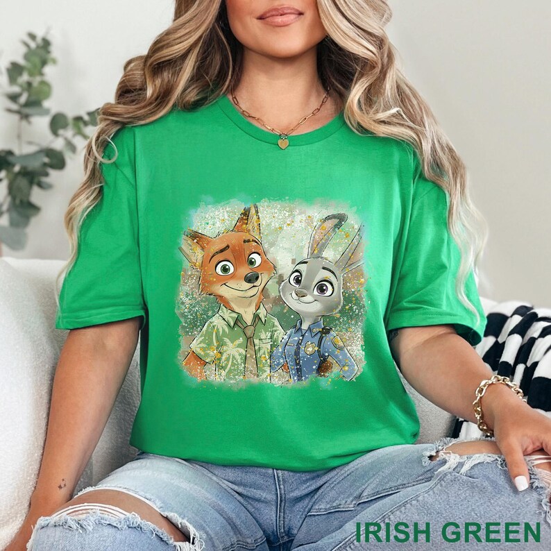 K&ouml;nnte beinhalten: Ein gr&uuml;nes T-Shirt mit einem Cartoon-Bild eines Fuchses und eines Kaninchens. Der Fuchs tr&auml;gt ein Hawaiihemd und das Kaninchen eine Polizeiuniform. Der Text "IRISH GREEN" befindet sich am unteren Rand des T-Shirts.