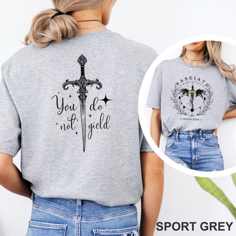 May include: Sport grey t-shirt featuring a detailed black sword design with the text "You do not yield" on the back. The front of the shirt displays a circular graphic with text and a sword design. The shirt is made of a soft material.