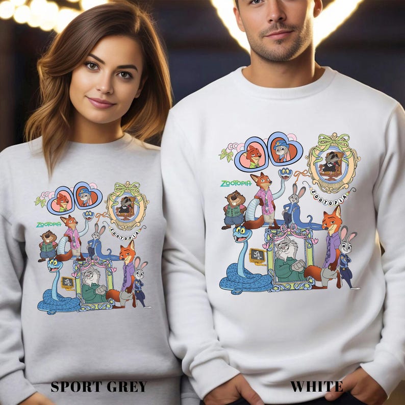 May include: Sport grey and white sweatshirts featuring a colorful graphic from the animated movie Zootopia. The design includes various characters in ornate frames and the word "Zootopia".
