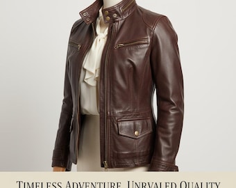 Puede incluir: Chaqueta de cuero marrón oscuro con cuello alzado, bolsillos con cremallera y cierre frontal con cremallera. La chaqueta se exhibe en un maniquí. El texto en la parte inferior dice: TIMELESS ADVENTURE. UNRIVALED QUALITY. DISCOVER YOUR JOURNEY. SHOP NOW.