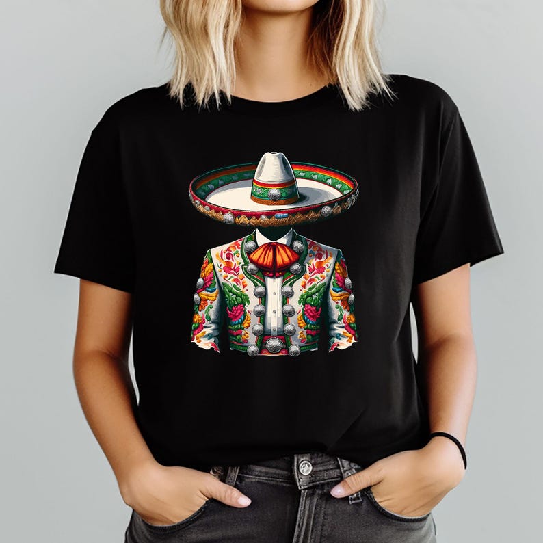 May include: Black t-shirt featuring a colorful illustration of a traditional Mexican mariachi outfit. The design includes a sombrero, a decorated jacket with silver buttons, and a red bow tie. The artwork is vibrant and detailed.