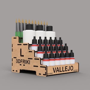Puede incluir: Organizador de botellas de pintura de madera con el texto "3DFriki" y "Vallejo" impreso en él. El organizador tiene varios estantes para guardar pequeñas botellas de pintura. Hay 24 botellas de pintura en el organizador, con tapas negras y etiquetas rojas y blancas.
