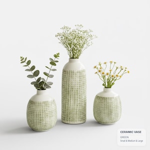 Può includere: Tre vasi in ceramica verde e bianco con motivo a griglia. I vasi sono di dimensioni piccola, media e grande e contengono eucalipto, gipsofila e margherite. Il testo sull'immagine recita: CERAMIC VASE GREEN Small & Medium & Large.