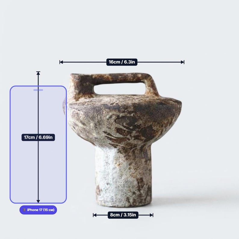 May include: A textured, brown and grey ceramic vessel with a cylindrical base, a wide upper body, and a top handle. The object measures 6.3 inches in width and 3.15 inches at the base. A diagram indicates a total height of 6.69 inches.
