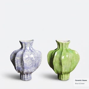 May include: Two ceramic vases with a bulbous, ribbed shape and a narrow neck. One vase features a mottled light blue and white finish, while the other has a mottled light green and white finish. The text "Ceramic Vases Blue & Green" is visible.