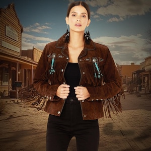 May include: A brown suede jacket with fringe detailing and turquoise bead accents. The jacket has a snap closure and a collar.