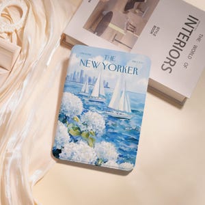 Könnte beinhalten: Eine Tablet-Hülle mit einer Aquarellillustration von Segelbooten auf dem Wasser mit der Skyline von New York im Hintergrund. Die Hülle hat ein blaues und weißes Farbschema mit dem Text "THE NEW YORKER".