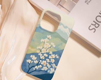 May include: A phone case featuring a watercolor design of a mountain landscape and flowering branches. The case has a blue, green, and white color scheme. The design includes a mountain range and a flowering tree.