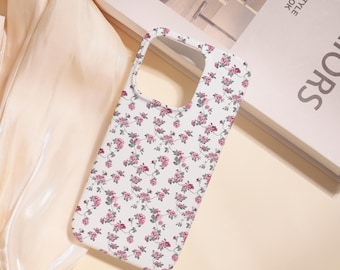 May include: A white phone case with a floral pattern of small pink roses and green leaves. The case has a rectangular shape with rounded corners and cutouts for the camera and buttons. The floral design covers the entire surface of the case.