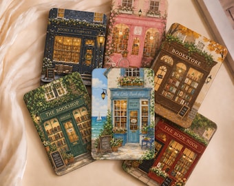 May include: Six rectangular metal tins featuring detailed illustrations of various storefronts, including Books & Company, Wild Rose Bookshop, The Bookshop, The Little Bookshop, Bookstore, and The Book Nook, each with unique colors, signage, and window displays.