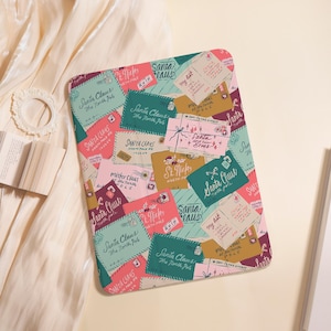 May include: A rectangular tablet case featuring a festive pattern of overlapping envelopes addressed to Santa Claus. The design includes various colors like teal, pink, and gold, with handwritten-style text such as Santa Claus, The North Pole, and My list.