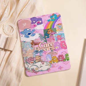 May include: Pink tablet case featuring a collage of Care Bears characters, rainbows, and cupcakes. The case has a repeating pattern of butterflies and the words "Care Bears" in a whimsical font. The overall design is colorful and playful.