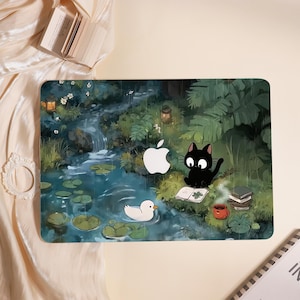 Könnte beinhalten: Eine Laptop-Hülle mit einer skurrilen Illustration einer ruhigen Teichszene mit einer schwarzen Katze, einer weißen Ente und einem Apple-Logo. Das Design umfasst einen Wasserfall, Seerosen und einen Stapel Bücher, alles in einem weichen, malerischen Stil.