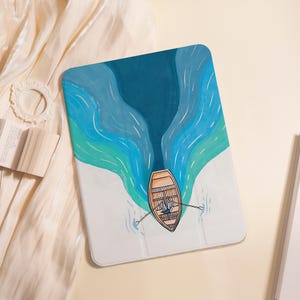 Może przedstawiać: Białe etui na tablet z akwarelową ilustracją łodzi wiosłowej na niebieskiej i turkusowej rzece. Łódź jest pomarańczowa z osobą wiosłującą. Tło jest białe.