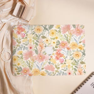May include: A laptop case with a floral pattern in shades of pink, yellow, and peach. The design features various flowers and green leaves on a white background. The Apple logo is visible.