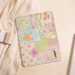 May include: A rectangular, patchwork-style notebook cover with various floral, fruit, and starfish designs. The cover features a mix of pastel colors, including pink, green, and yellow, with framed illustrations of a starfish, strawberries, and a bird.