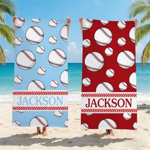 May include: Two beach towels with baseball designs. One is light blue with white baseballs and the name "JACKSON" in blue. The other is red with white baseballs and the name "JACKSON" in white.