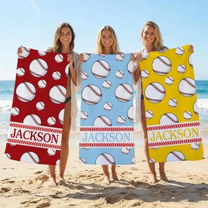 May include: Three beach towels with baseball designs. One is red, one is light blue, and one is yellow. Each towel has a repeating pattern of baseballs and the name "JACKSON" in a white banner with red stitching.