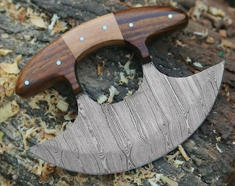 May include: A curved, stainless steel knife with a wooden handle. The blade has a hammered finish and the handle is made of two different types of wood.