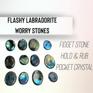May include: Flashy labradorite worry stones. Oval-shaped stones in shades of blue, green, and gold. Text on the image reads "Fidget Stone, Hold & Rub, Pocket Crystal."
