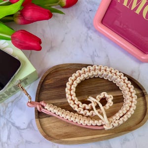 Ecru macramé telefoonbandje – Vanille & roze perzik koord – Chique handgemaakte smartphone accessoire – Sterk paracord