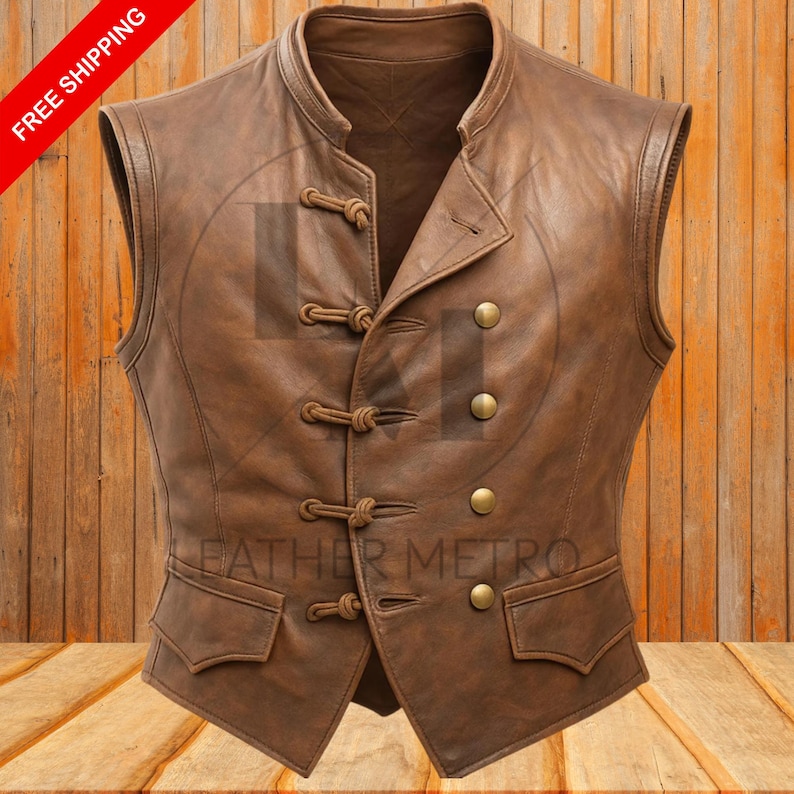 Pode incluir: Colete de couro castanho com gola mandarim, bot&otilde;es decorativos e dois bolsos frontais. O colete tem fecho de bot&atilde;o e um corte sob medida. O texto "LEATHER METRO" &eacute; vis&iacute;vel no colete.