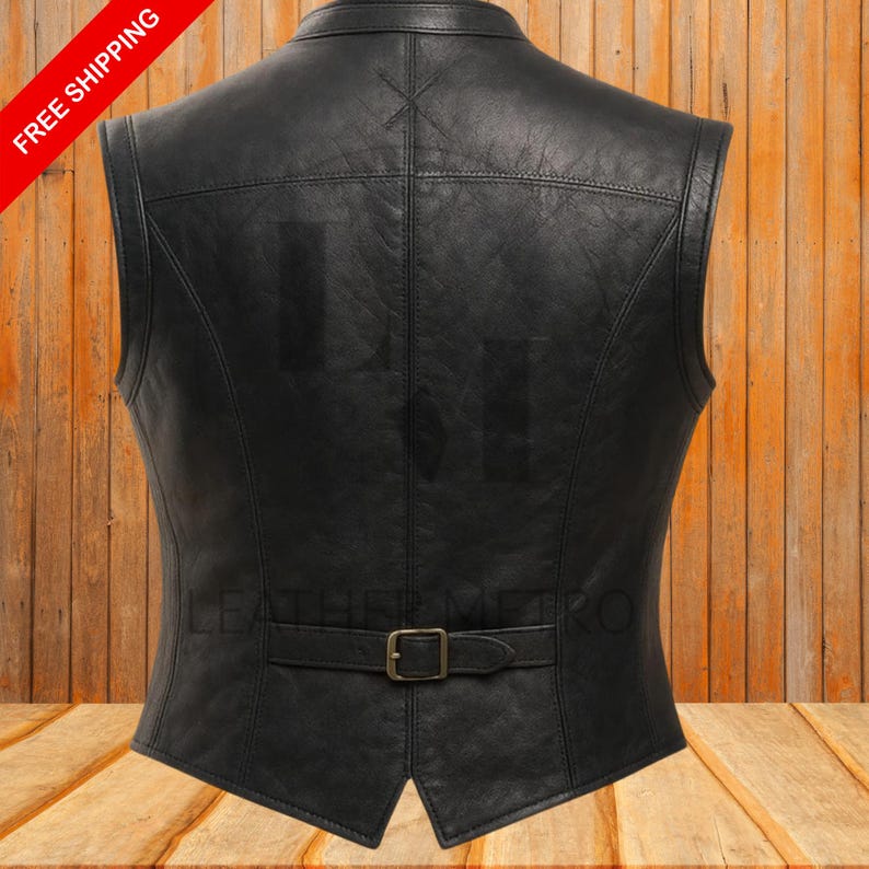 Pode incluir: Colete de couro preto com gola entalhada e fecho de fivela na cintura. O colete tem um ajuste sob medida e apresenta um design costurado nas costas. As palavras "FREE SHIPPING" s&atilde;o impressas em uma faixa diagonal vermelha.